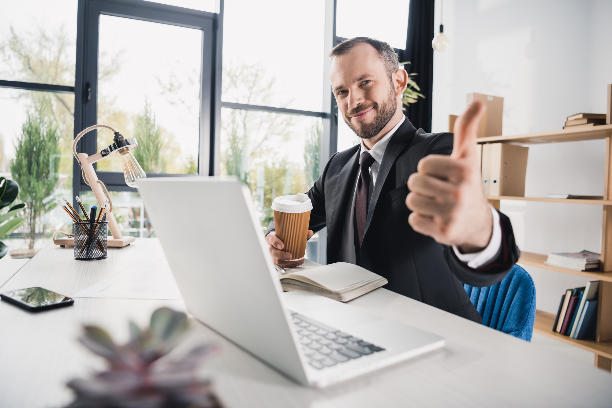 handsome young businessman showing thumb up